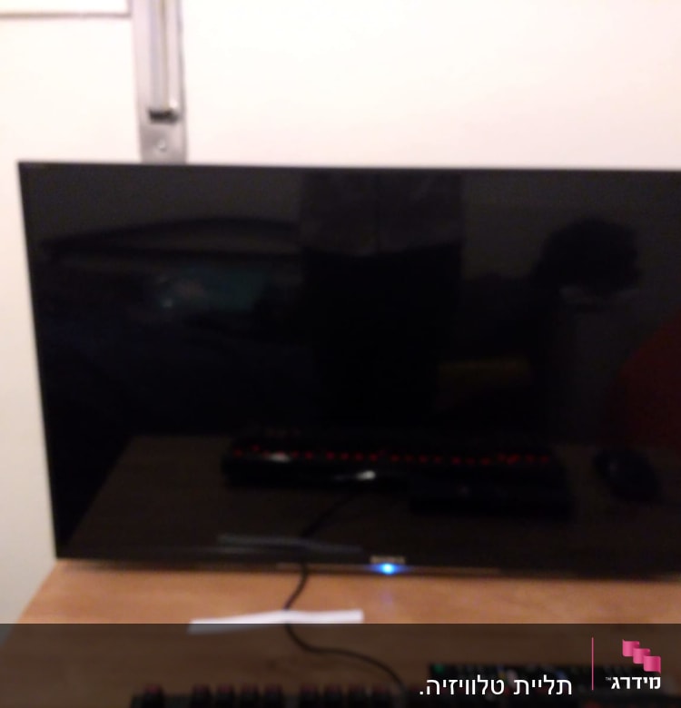 מסך טלוויזיה על שולחן עם שלטים ומקלדת